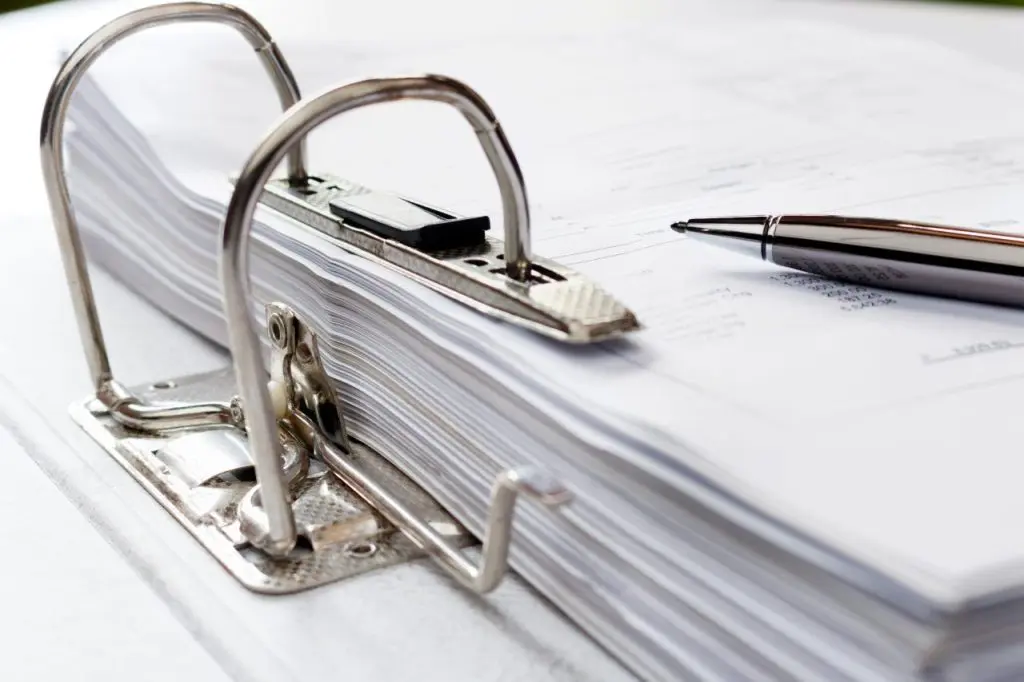 Stylo sur dossier contenant des documents, stockage des contrats